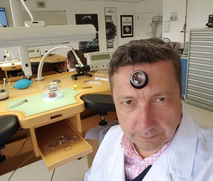 A professional taking selfie while repairing watch